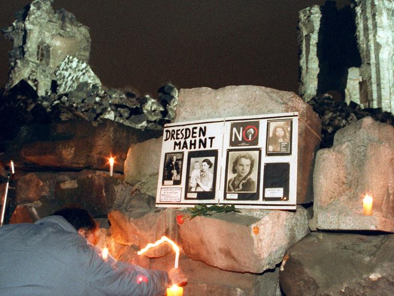 Dresdner Bürger stellen am 13. Februar 1993 brennende Kerzen an die Ruine der Frauenkirche auf dem Neumarkt.