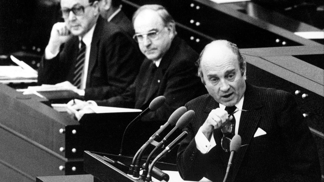 Wirtschaftsminister Otto Graf Lambsdorff (FDP) redet 1982 im Bonner Bundestag. Im Hintergrund Bundeskanzler Helmut Kohl (CDU) und Außenminister Hans-Dietrich Genscher.