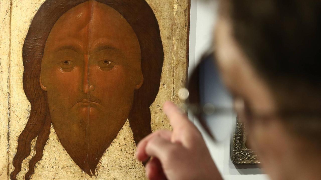Mann zeigt auf russische Christus-Ikone