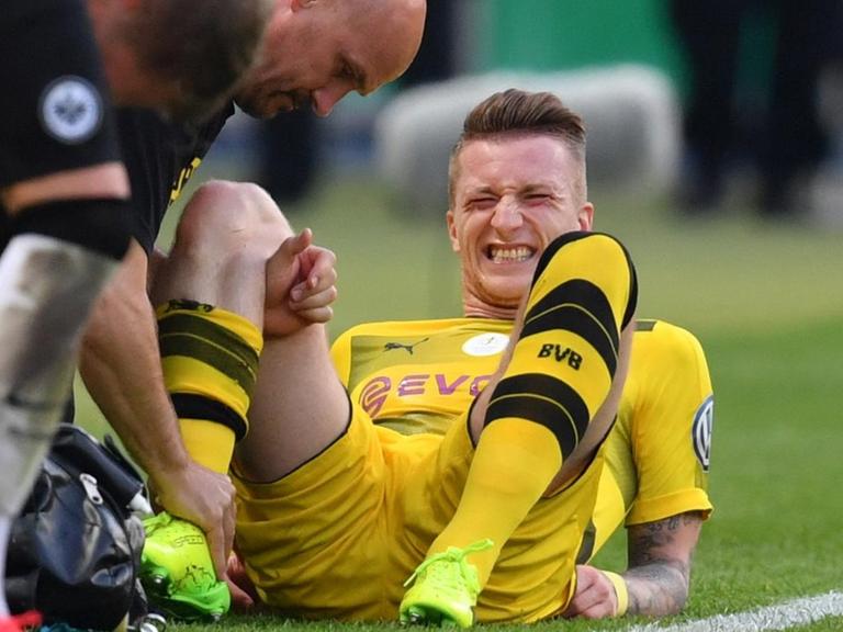Dortmunds Marco Reus wird am Spielfeldrand behandelt.