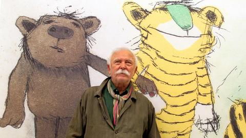 Janosch posiert vor seinem Bild "Der Tiger mit grüner Nase".