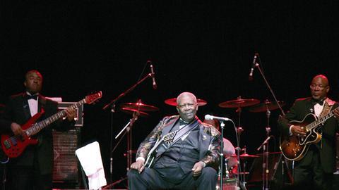 B. B. King sitzt auf einer Bühne.