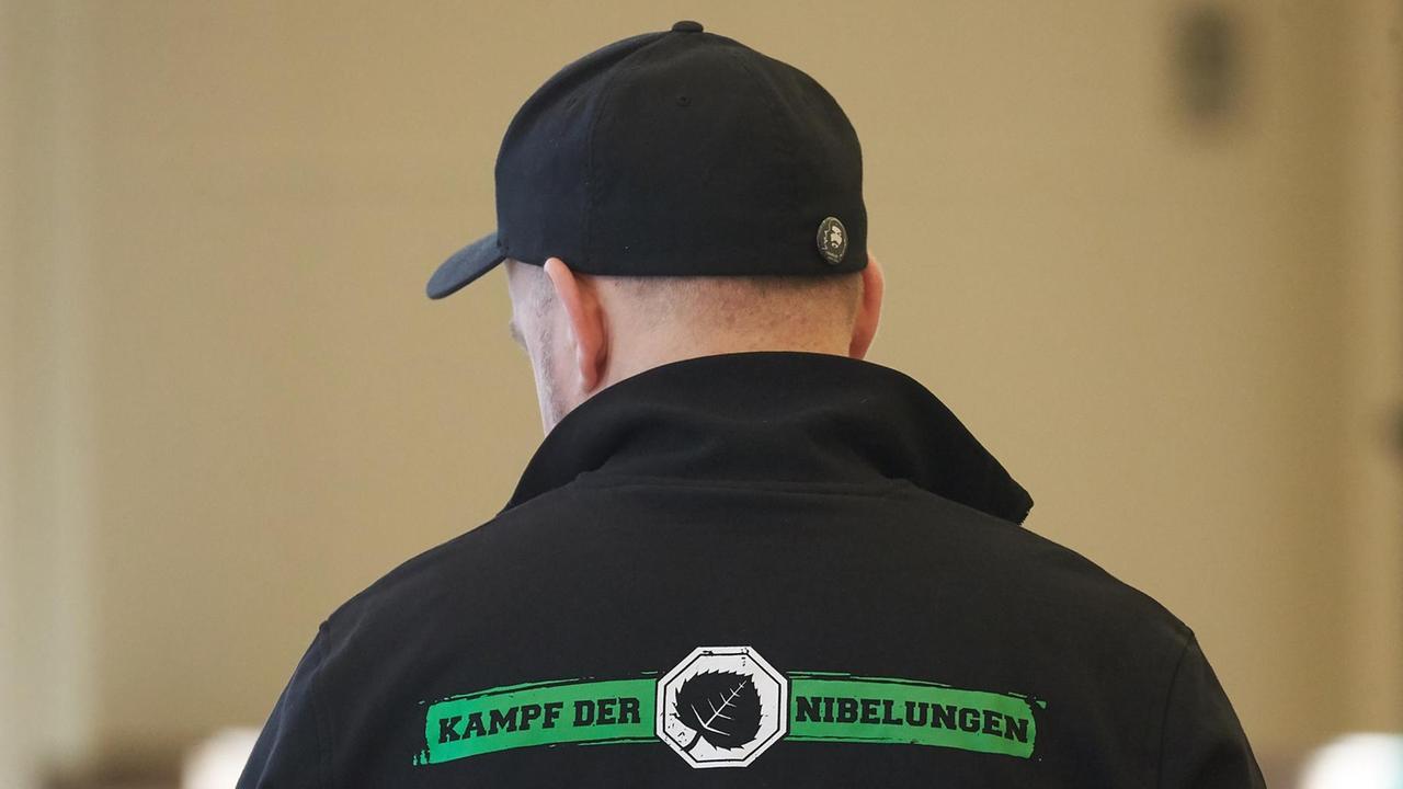 Das Foto zeigt in der Rückansicht einen der Angeklagten im Verfahren gegen mutmaßliche Mitglieder des «Aktionsbüros Mittelrhein». Sein Shirt trägt die Aufschrift "Kampf der Nibelungen - Disziplin ist alles!".