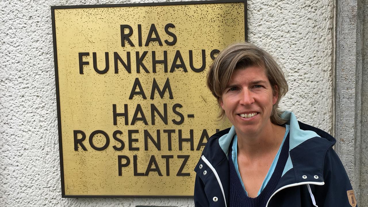 Hockeyspielerin Natascha Keller vor dem RIAS-Schild am Eingang des Hauses von Deutschlandfunk Kultur.