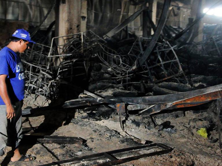 Ein pakistanischer Helfer steht in der ausgebrannten Textilfabrik in Karachi, Pakistan, am Tag nach der Brandkatastrophe.