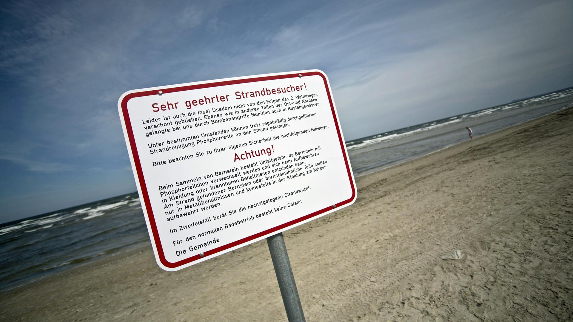Ein Schild mit Warnhinweisen vor phosphorhaltiger Weltkriegsmunition steht am Strand von Karlshagen auf Usedom.
