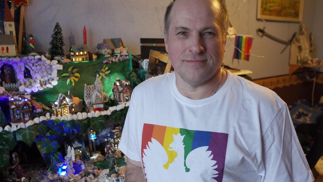 Bild eines Mannes mit Regebogen-T-Shirt in seiner Wohnung