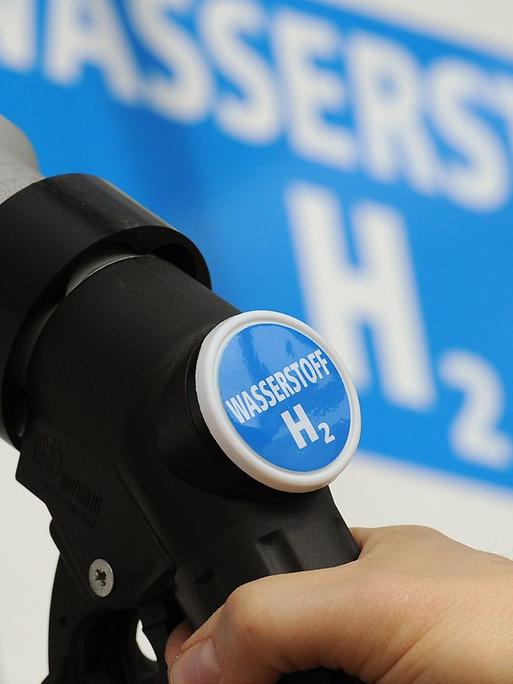 Ein Mann hält am 18.04.2012 den Zapfhahn einer Wasserstoff-Tanksäule an ein Auto auf einer Tankstelle in Berlin.