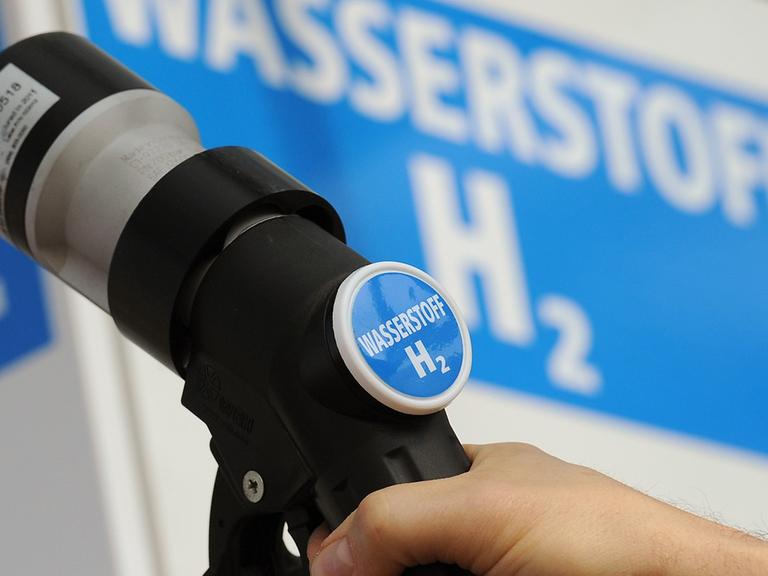 Ein Mann hält am 18.04.2012 den Zapfhahn einer Wasserstoff-Tanksäule an ein Auto auf einer Tankstelle in Berlin.