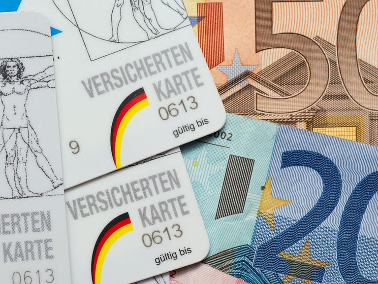 Krankenkassen-Karten liegen neben Euro-Scheinen.