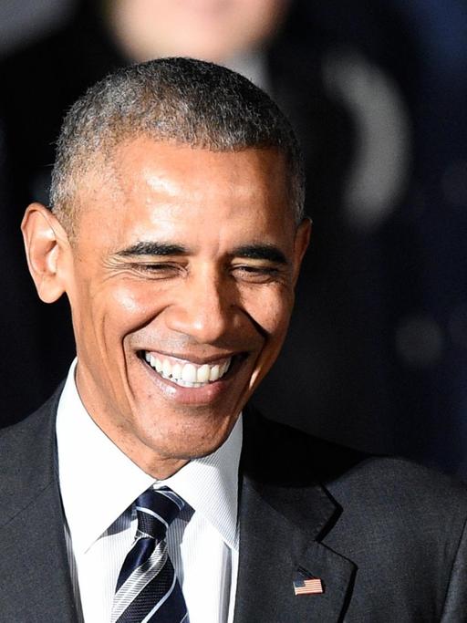 Sie sehen Präsident Obama, er lacht.