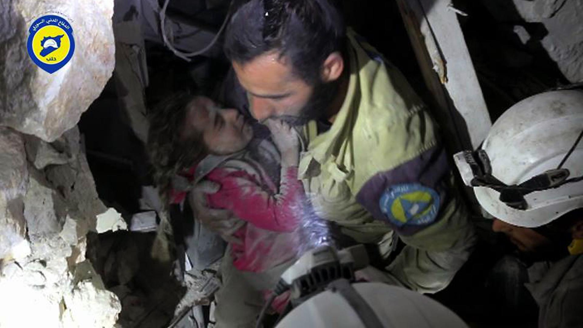 Ein Mitglied der Hilfsorganisation Weißhelme birgt ein Kind aus den Trümmern.