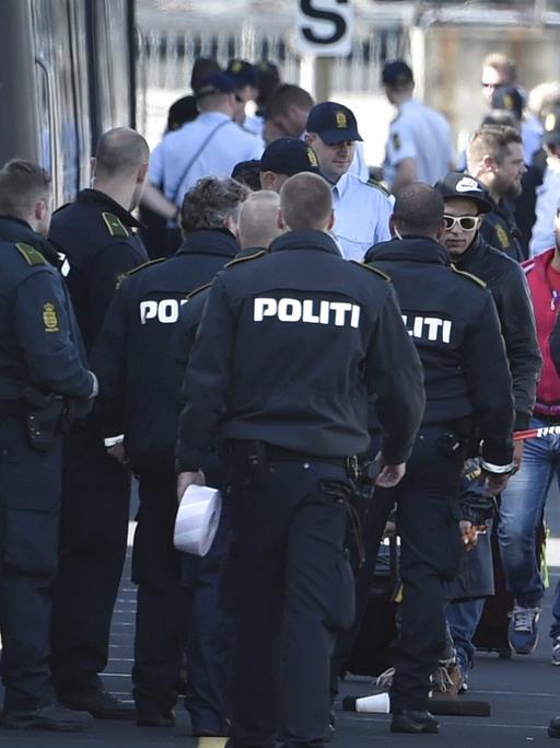 Dänische Polizisten stehen in Rødby vor einem ICE.