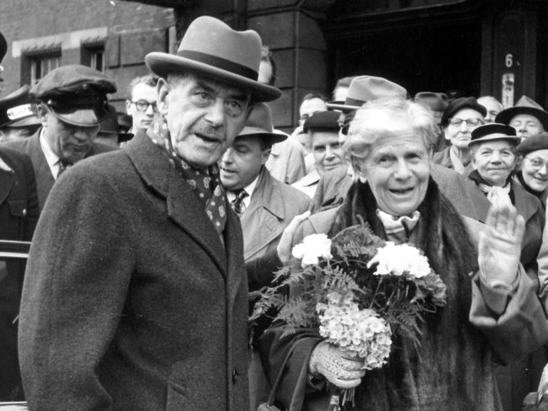 Der Schriftsteller Thomas Mann mit seiner Ehefrau Katia am Lübecker Hauptbahnhof 1955. Anlass des Besuchs seiner Geburtsstadt war die Verleihung der Ehrenbürgerwürde.