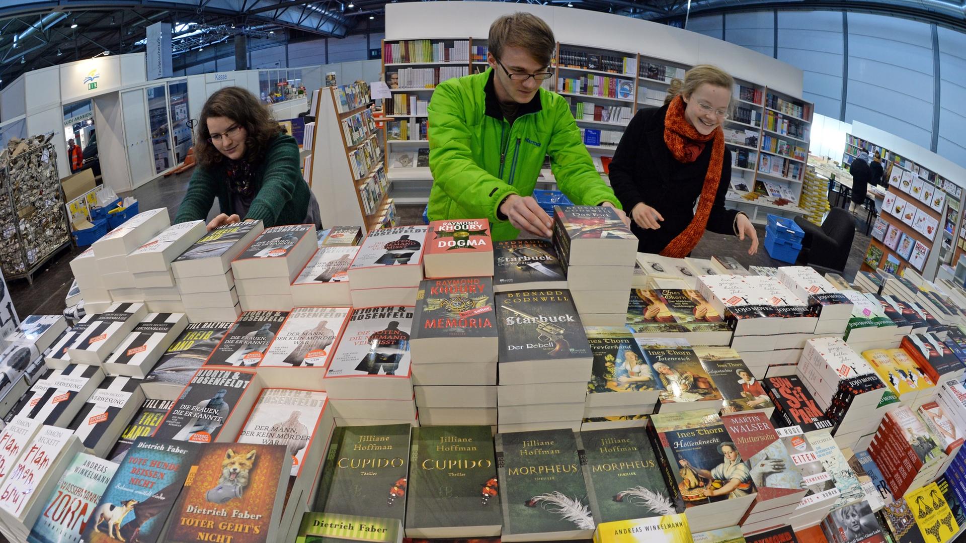 Mitarbeiter der Messebuchhandlung bereiten am 12.03.2014 ihren Stand für die Eröffnung der Buchmesse in Leipzig (Sachsen) vor. Vom 13. bis 16. März präsentieren sich auf der Messe 2000 Verlage mit ihren Neuerscheinungen. Foto: Hendrik Schmidt/dpa Mitarbeiter der Messebuchhandlung bereiten am 12.03.2014 ihren Stand für die Eröffnung der Buchmesse in Leipzig (Sachsen) vor. Vom 13. bis 16. März präsentieren sich auf der Messe 2000 Verlage mit ihren Neuerscheinungen. Foto: Hendrik Schmidt/dpa