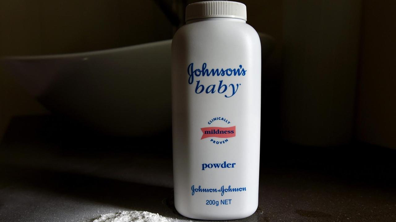 Eine weiße Flasche mit dem Babypuder steht vor einem schwarzen Hintergrund. 