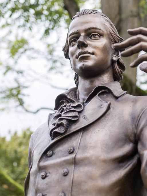 Bild der Statue von Friedrich Hölderlin unter Bäumen in Nürtingen.