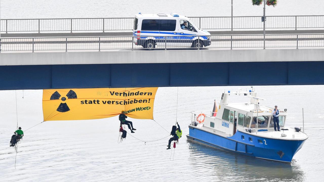 Atomkraftgegner der Umweltschutzorganisation "Robin Wood" seilen sich von einer Brücke über dem Neckar ab und enthüllen ein Transparent mit der Aufschrift "Verhindern statt verschieben"