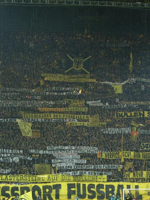 Dortmunder Fans entrollen (04.02.17) vor Spielbeginn auf der Südtribüne Spruchbänder, mit denen sie den RB Leipzig kritisieren.