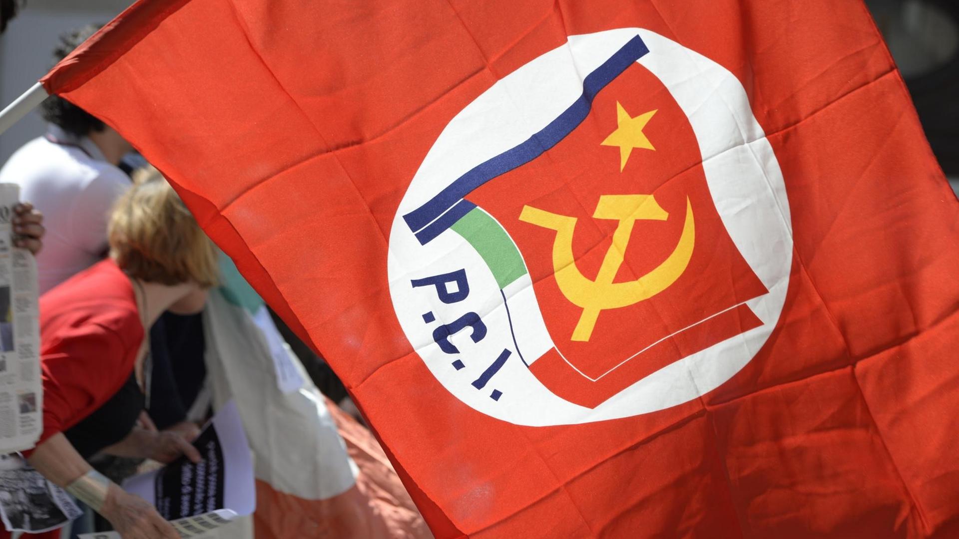 Ein Demonstrant trägt eine Flagge der Kommunistischen Partei Italiens (PCI) bei einer Kundgebung vor dem Parlament in Rom im April 2013