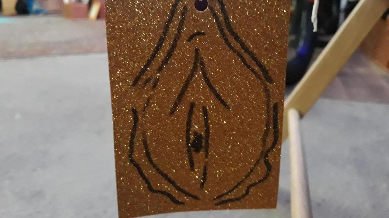 Die Eintrittskarte für den Vulvaversity-Workshop: Eine auf gold-glitzernder Pappe gemalte Vulva
