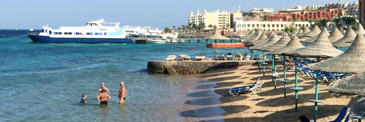 Ägypten, Hurghada: Touristen stehen im Wasser an einem Hotel-Strand in Hurghada.