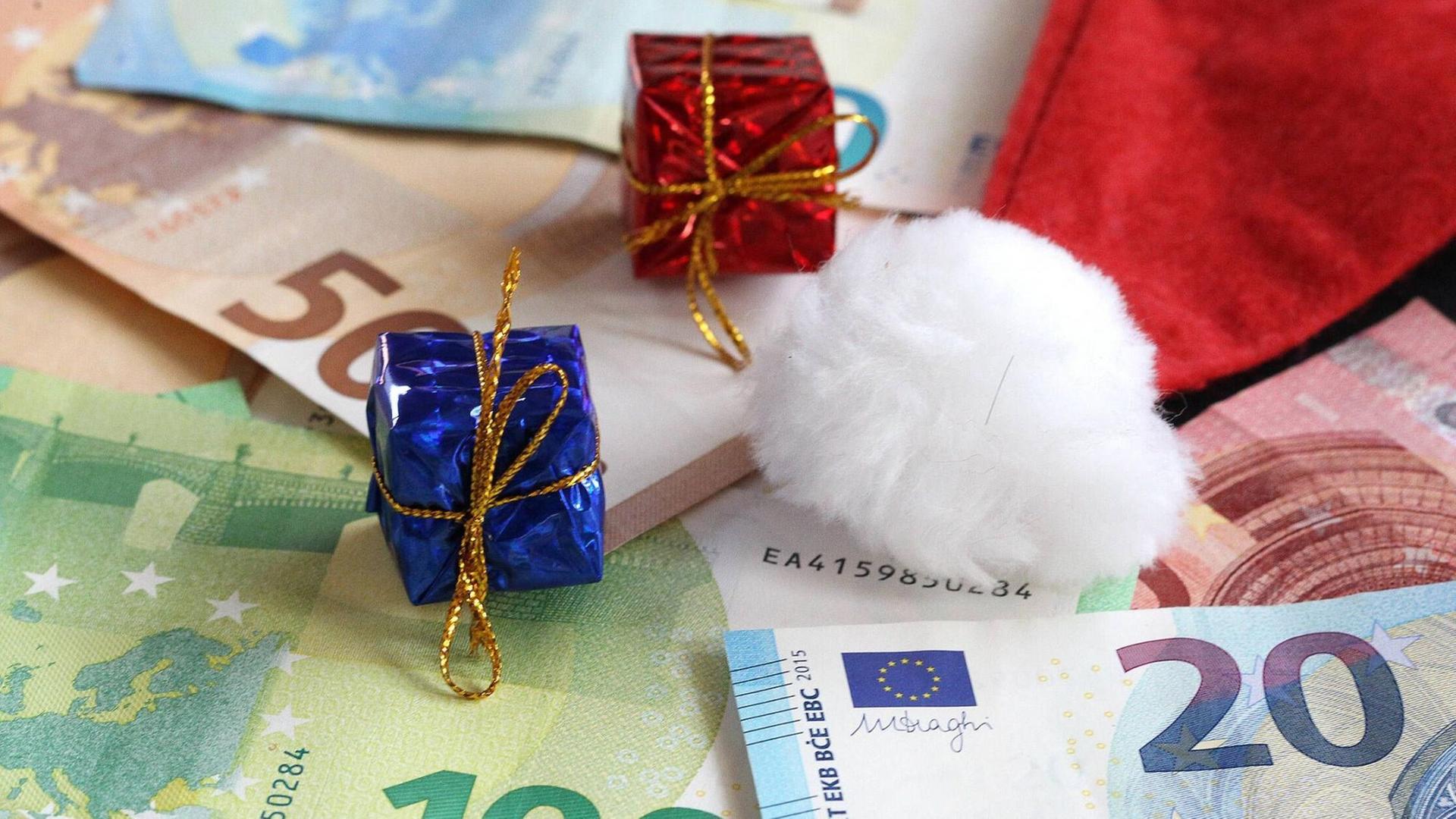 Kleine Weihnachtsgeschenke mit Euro Banknoten und einer Nikolausmütze.
