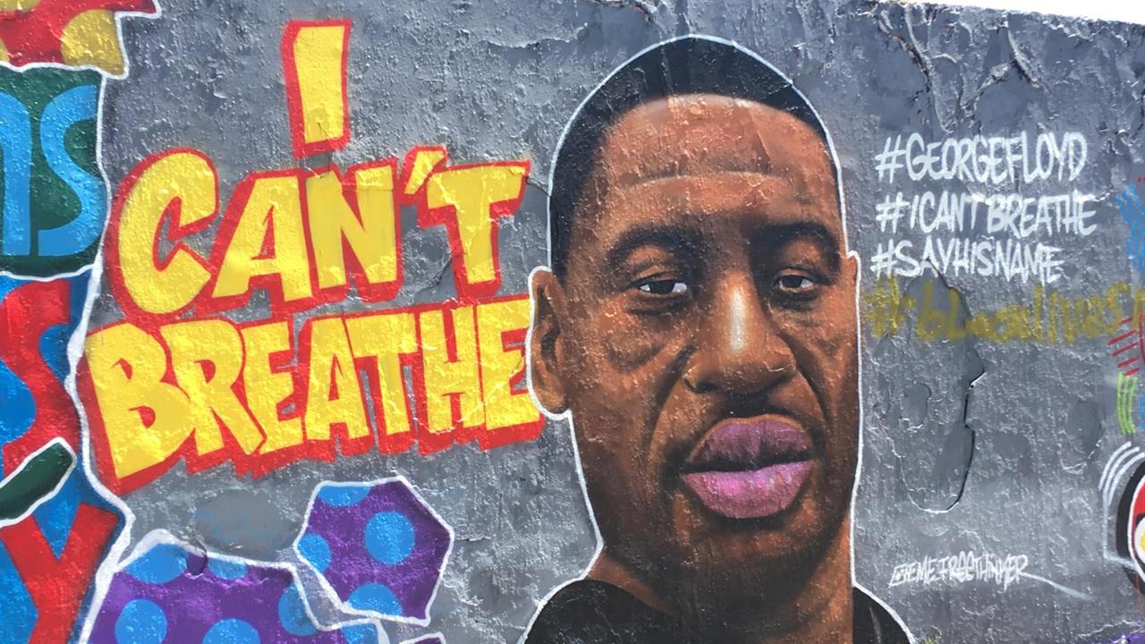 Ein Porträt von George Floyd gemalt auf eine bunte Wand mit den Buchstaben "I can't breathe.