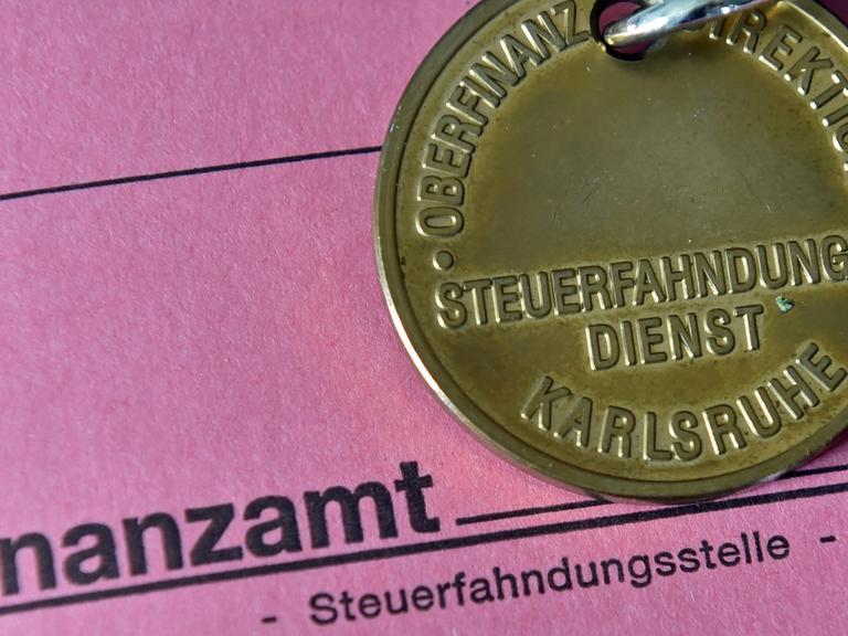 Dienstmarke eines Steuerfahnders auf einer Akte des Finanzamts