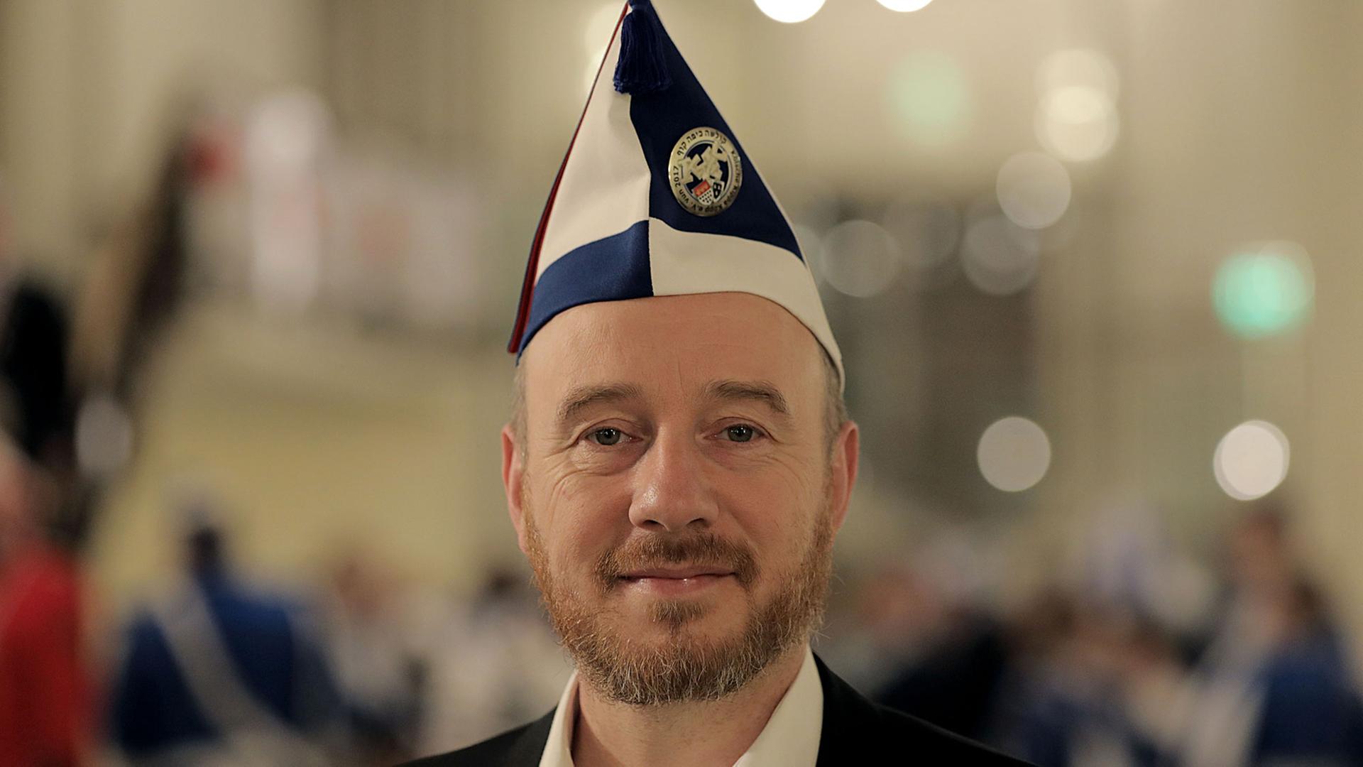Aaron Knappstein, Präsident des jüdischen Karnevalsvereins "Kölsche Kippa Köpp", steht vor dem Besuch einer Sitzung im Foyer einer Halle in Köln.