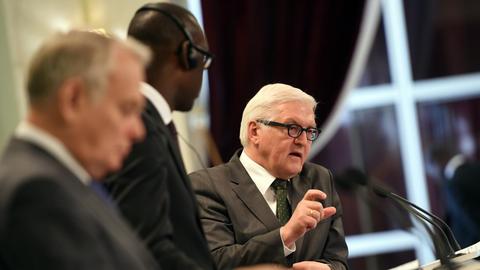 Frank-Walter Steinmeier spricht an einem Mikrofon, im Vordergrund sind seine Amtskollegen aus Frankreich und Mali, Jean Marc Ayrault und Abdoulaye Diop zu sehen, die ihn anschauen.