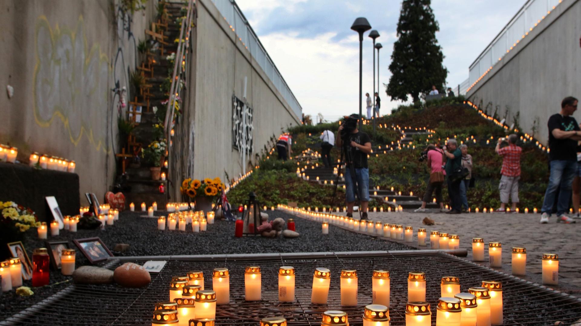 Kerzen stehen am 23.07.2013 nahe der Gedenkstätte der Loveparade in Duisburg (Nordrhein-Westfalen) am Jahrestag der Katastrophe. Drei Jahre nach dem Loveparade-Unglück haben die Hinterbliebenen zum «Tag der 1000 Lichter» aufgerufen. Foto: Roland Weihrauch
