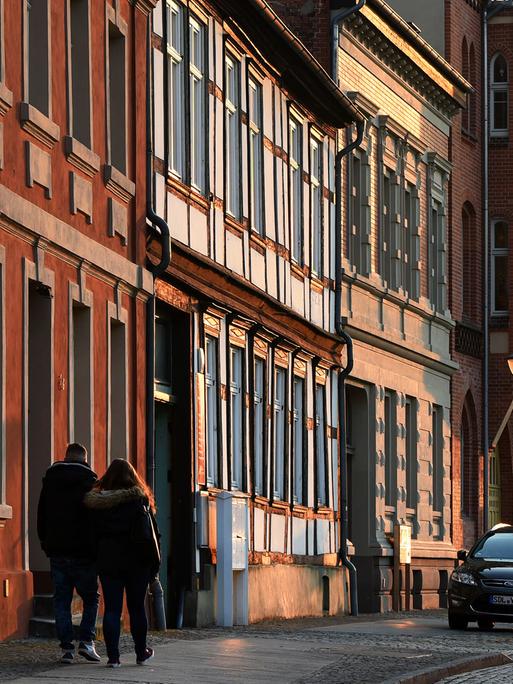 Sanierte Fachwerkhäuser sind in Stendal (Sachsen-Anhalt) in der Altstadt am Abend von der untergehenden Sonne beleuchtet.