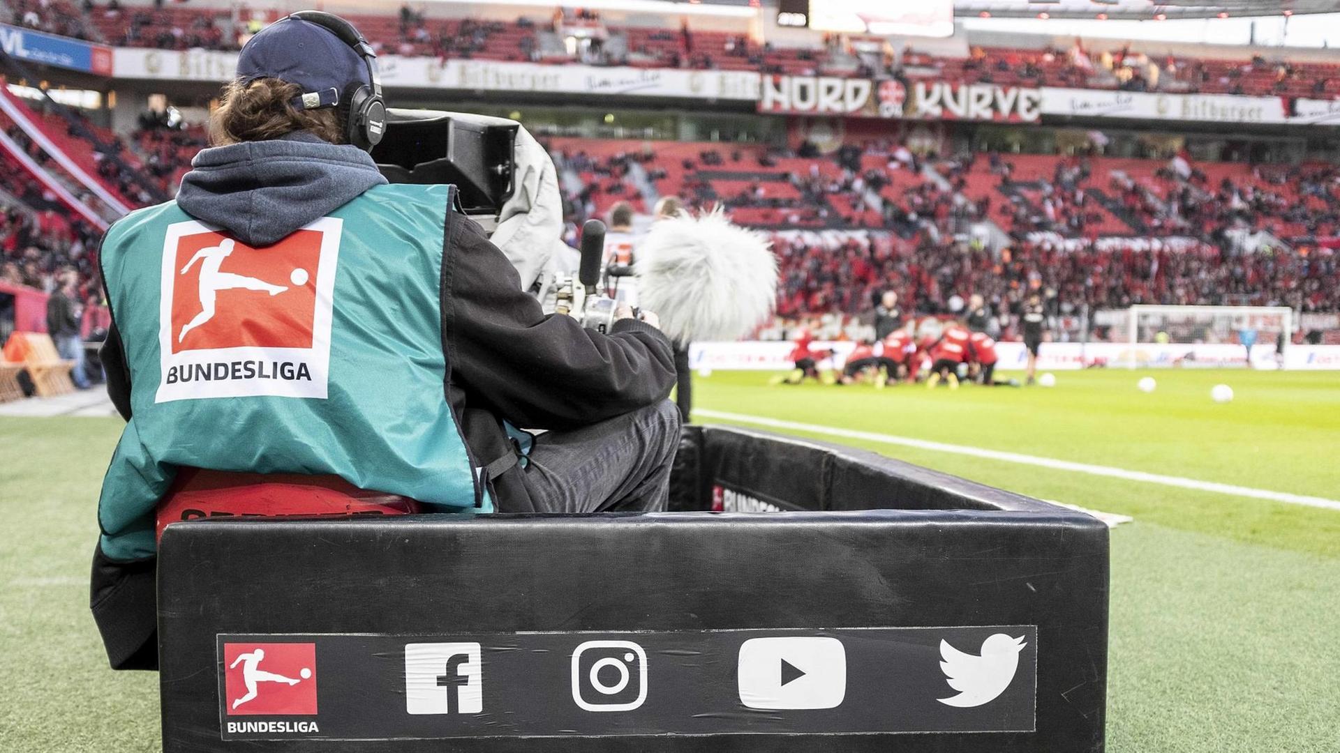 TV-Kameramann filmt am Spielfeldrand während der Live-Übertragung eines Spiels der Fußball-Bundesliga