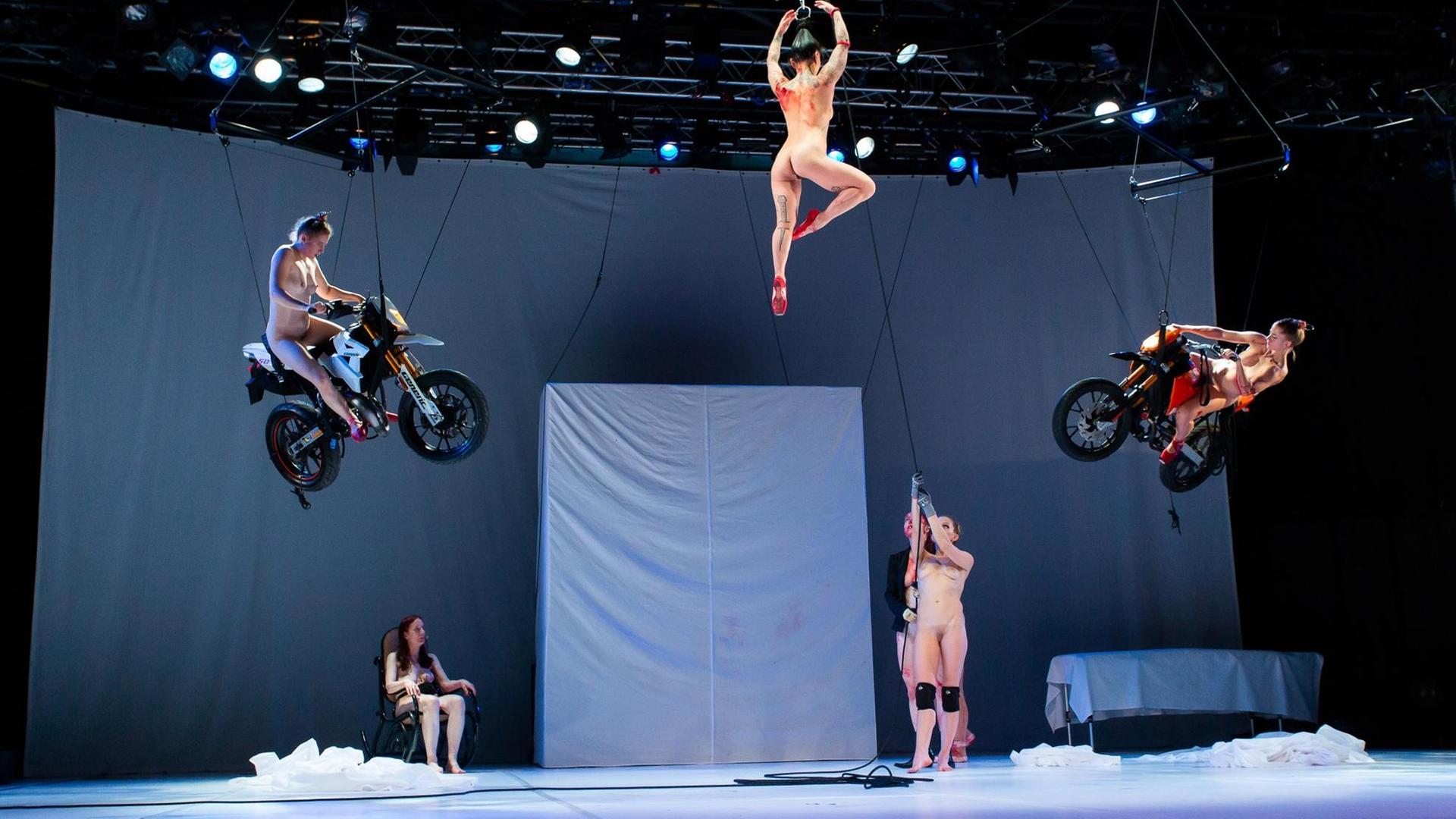 Künstlerinen schweben im Stück "Tanz" nackt auf Motorrädern
