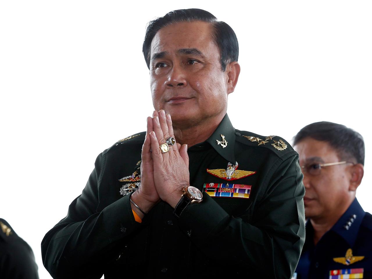 Armeechef Prayuth Chan-ocha steht mit zusammengelegten Handflächen da