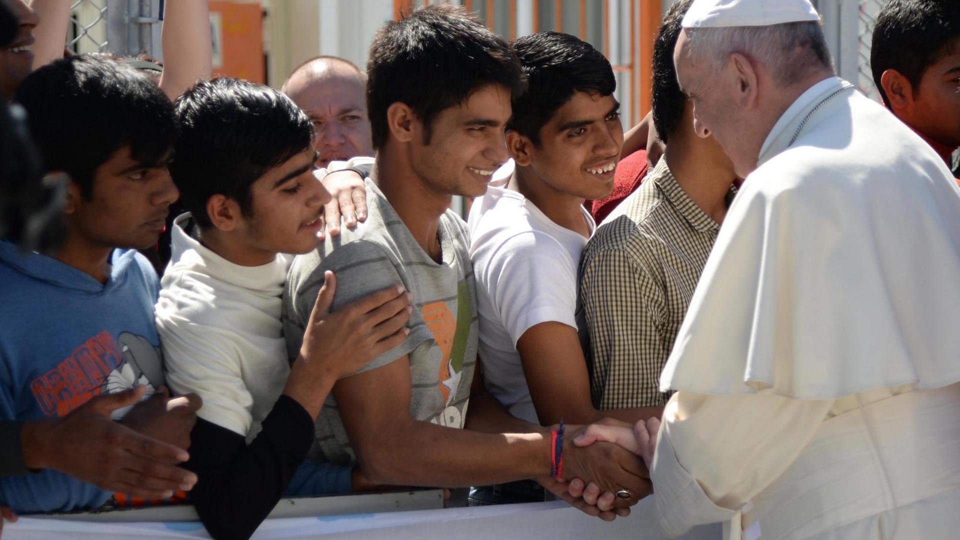 Papst Franziskus schüttelt jungen Flüchtlinge die Hand im Aufnahmezentrum Moria auf Lesbos