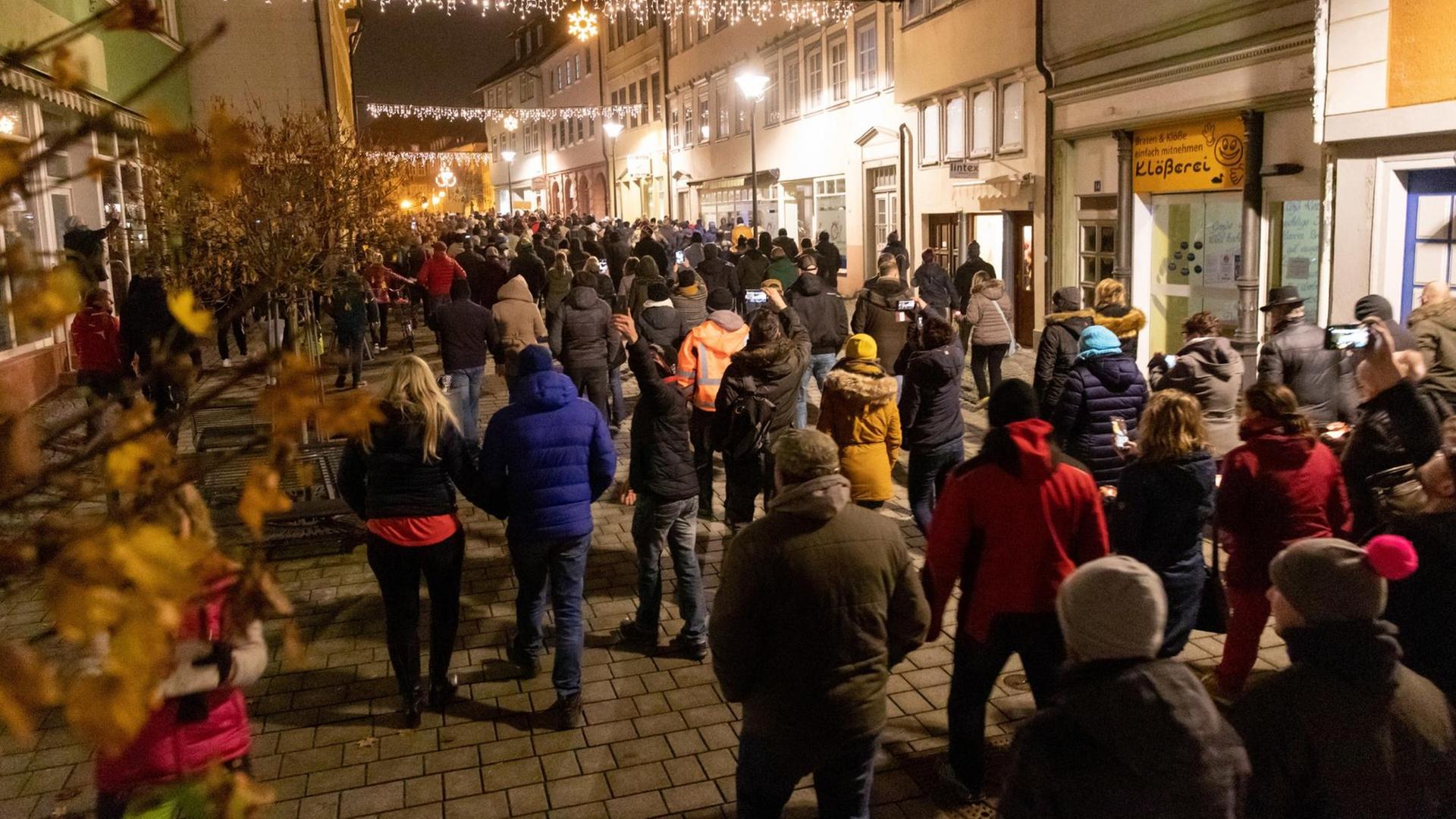Menschen laufen durch die Innenstadt von Hildburghausen in Thüringen und protestieren gegen die neuen Infektionsschutzregeln in dem Kreis.
