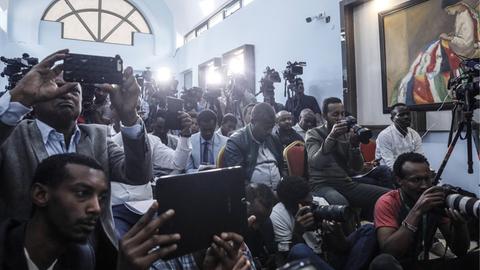 In einem schmalen, langgezogenen Raum eines Regierungsgebäudes in Äthiopiens Hauptstadt Addis Abeba drängen sich etliche Journalisten mit TV- und Fotokameras.