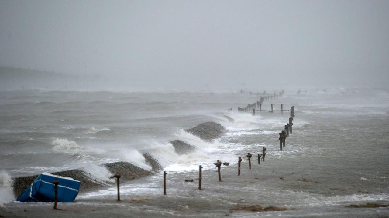 Ein Deich wird am 05.12.2013 in der größten nordfriesischen Hallig Langeneß (Schleswig-Holstein) in der Nordsee während des Orkans überspült.