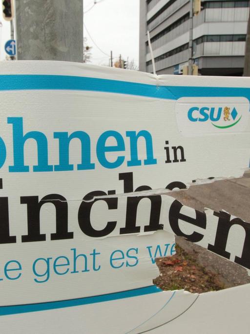 Ramponiertes Plakat der CSU mit Aufschrift "Wohnen in München"
