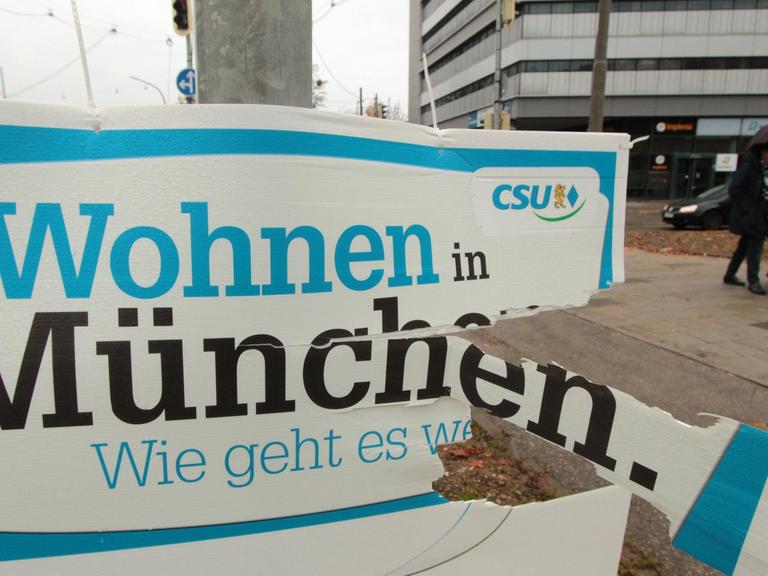 Ramponiertes Plakat der CSU mit Aufschrift "Wohnen in München"
