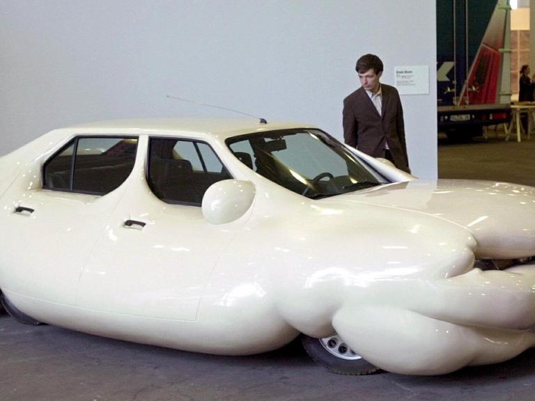Ein Besucher der Kunstmesse «Art 32» in Basel schaut sich bei einer Vorbesichtigung am 12.6.2001 das "Fette Auto" des Künstlers Erwin Wurm an.