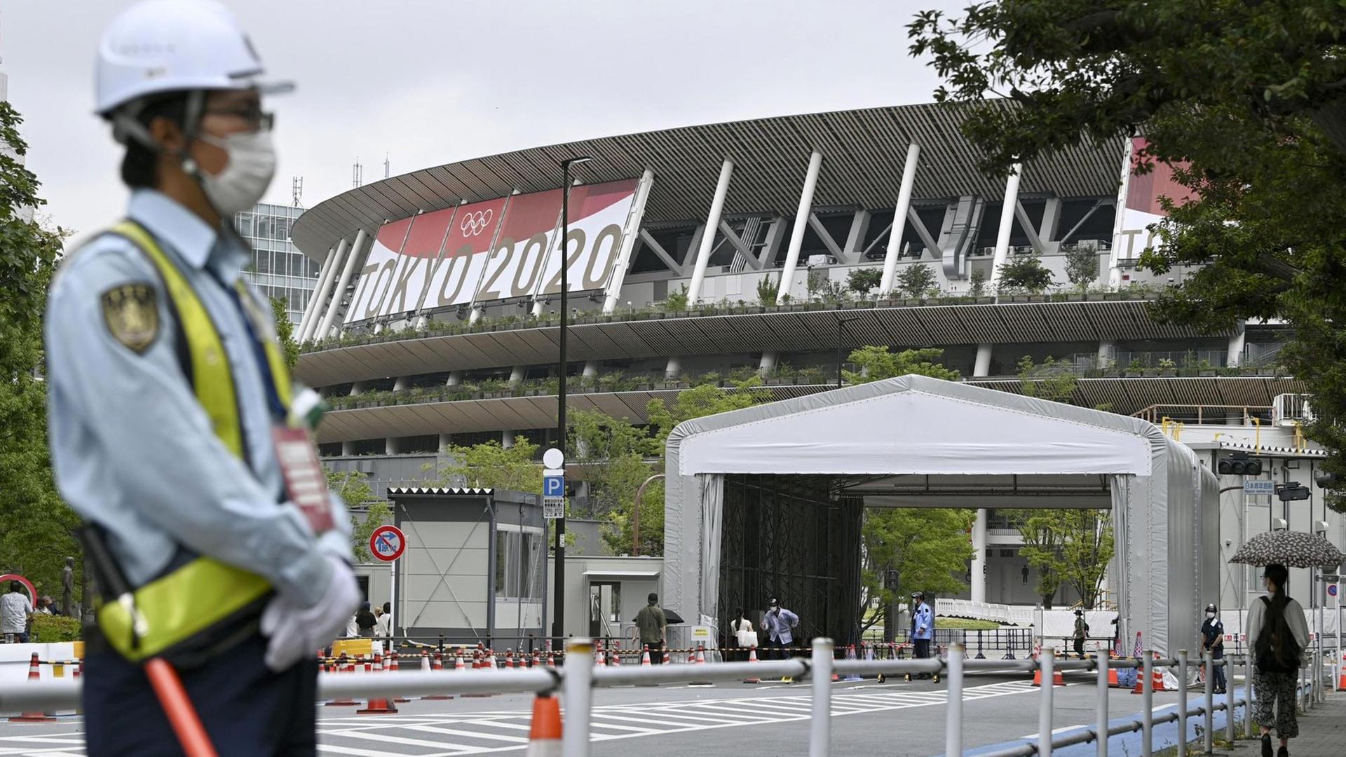Ein Mann steht vor dem Stadion in Tokio.