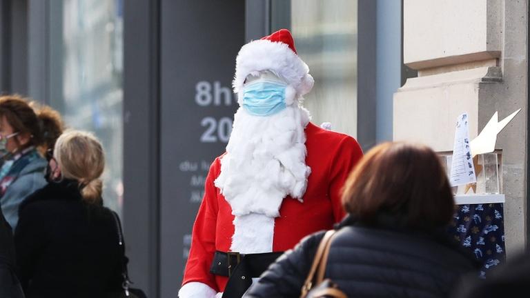 Pandemie und Bescherung: Weihnachtsmannfigur mit Maske in Paris Ende November 2020 Pandemie und Bescherung: Weihnachtsmannfigur mit Maske in Paris Ende November 2020