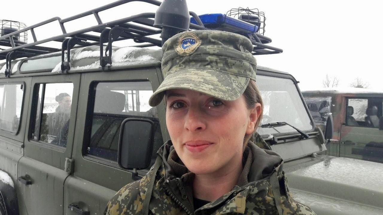 Ariana Selmanovic, Mitglied der Sicherheitskräfte des Kosovo, steht in Uniform vor einem Militär-Jeep