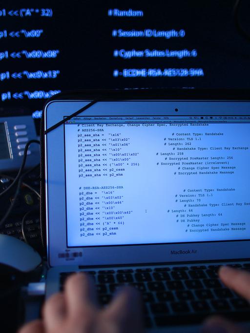 Ein Mann sitzt am 25.04.2013 in Köln (Nordrhein-Westfalen) vor einem Rechner mit Computer Quellcode auf dem Bildschirm.