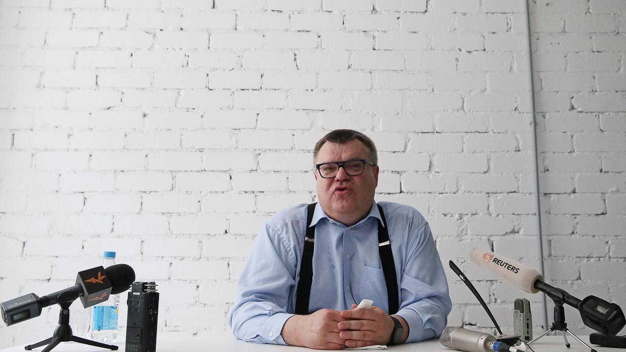 Viktor Babariko sitzt bei einer Pressekonferenz in Minsk an einem Schreibtisch