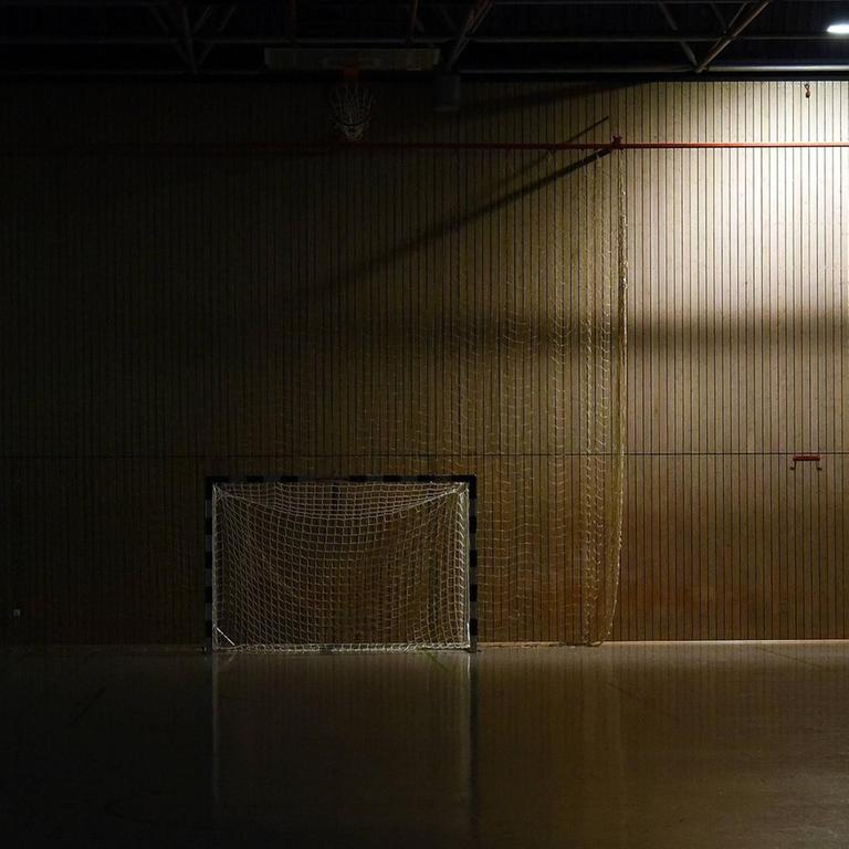 Ein dunkle und leere Sporthalle mit einem Handball-Tor.