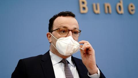 Spahn zieht seine FFP2-Maske bei einer Pressekonferenz ab (Archivbild).